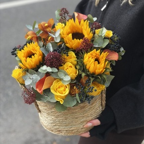 Композиция в сумке "Тональность" из подсолнухов, калл, ягод вибирнума, лимонных роз, скиммии и орхидеи в Лобне