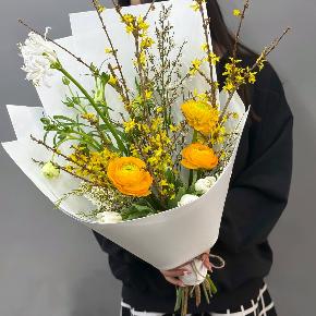 Весенний букет с желтыми ранункулюсами и цветущими ветками форзиции в Лобне